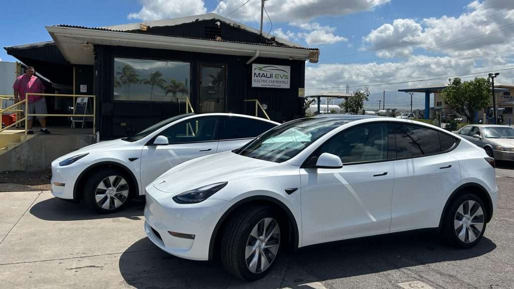 Two Tesla Model Ys parked in front of the Maui EVs office
