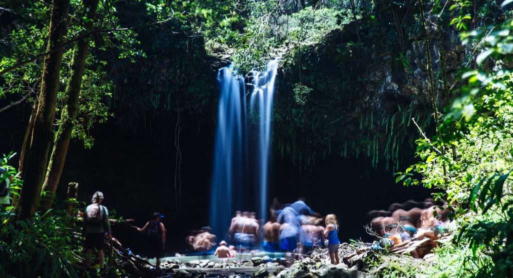 Twin Falls in Maui with people in the swimming hole and surrounding area