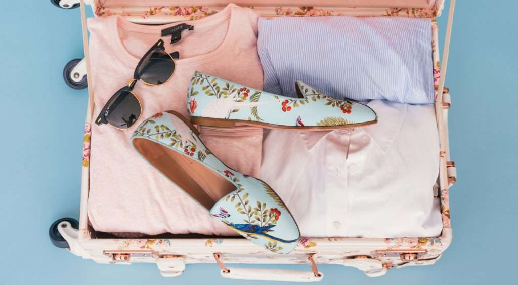 Suitcase neatly packed with mostly pink items