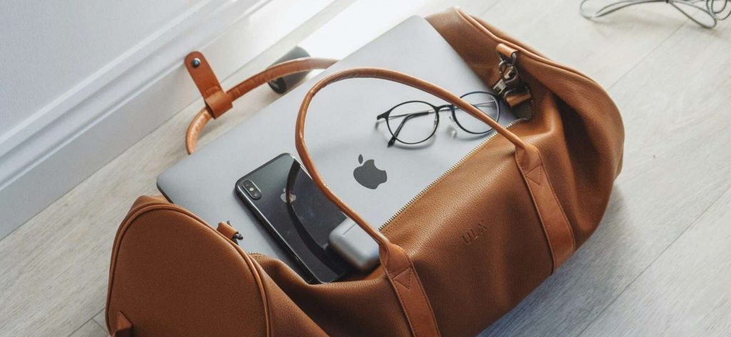 Apple products on top of a leather carrying bag