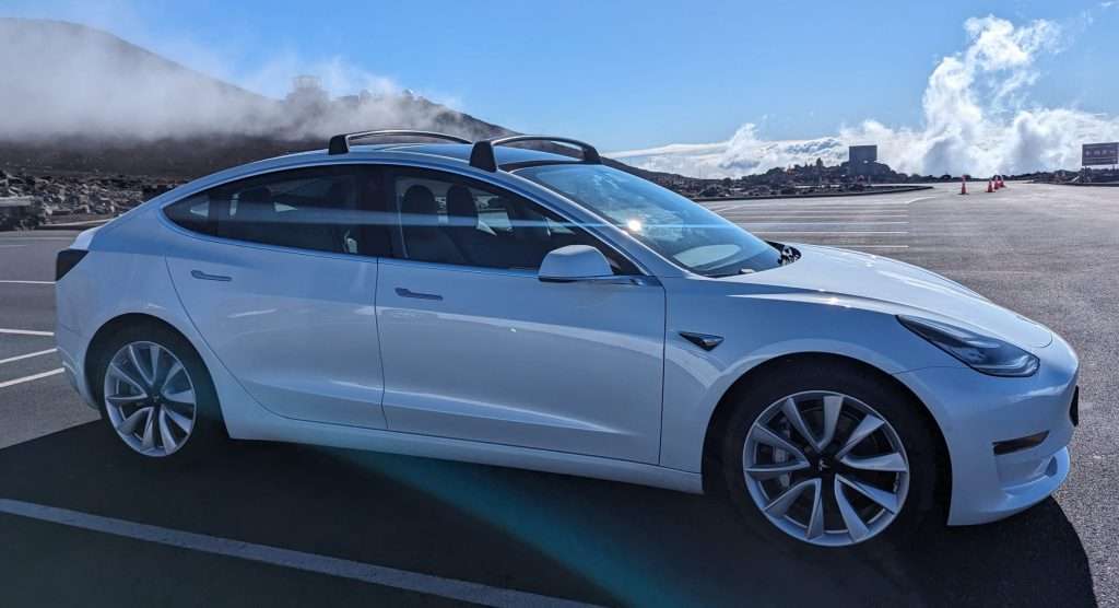 Tesla Model 3 at the second Haleakala visitors center parking lot above the clouds in the background